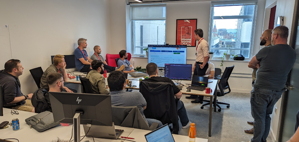 A group of people in an office looking at a screen