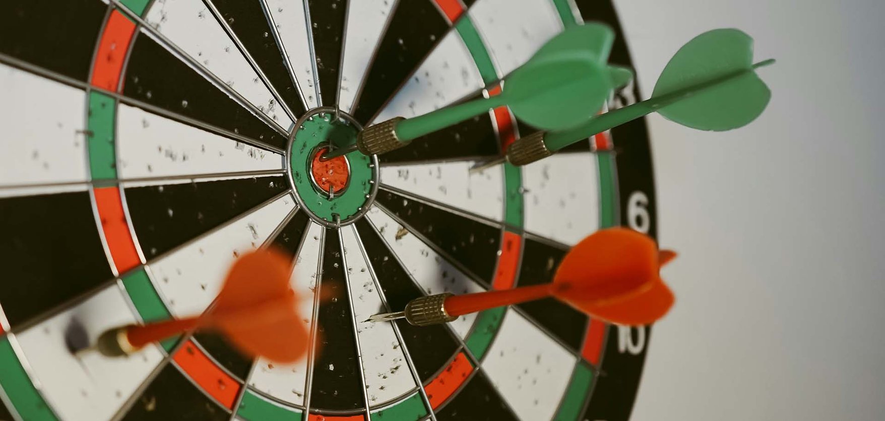 A close up of a dartboard with four darts