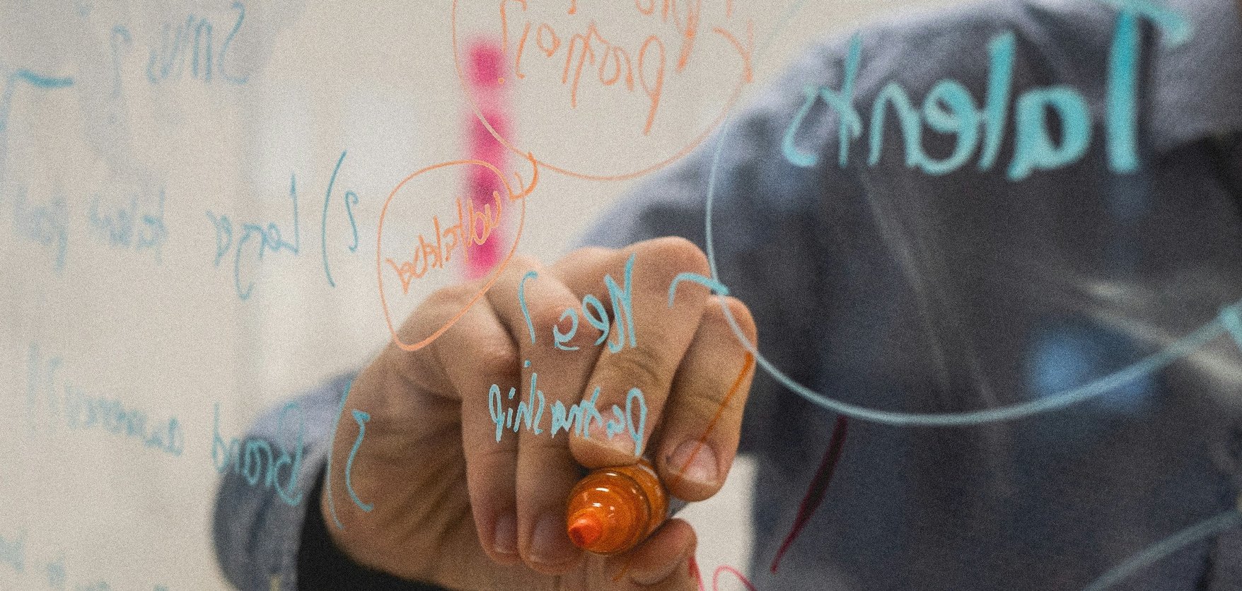 Person taking notes on clear screen